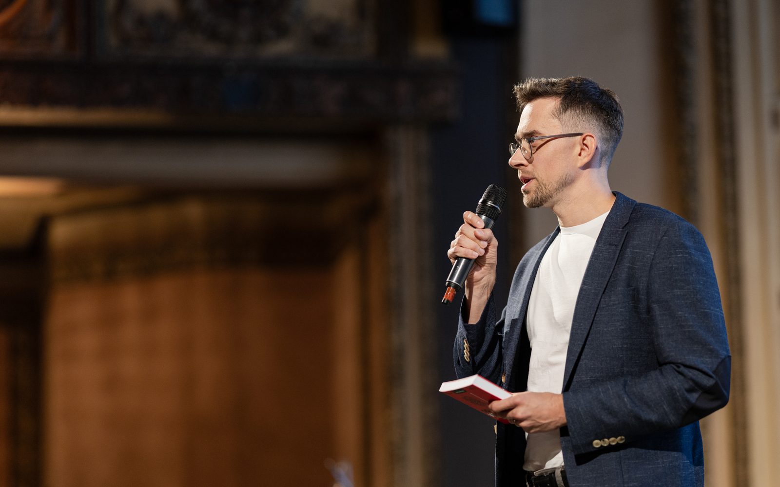 Lukáš Havránek přednáší s mikrofonem před publikem
